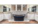 Spa-like bathroom with a black soaking tub and stone tile at 5713 W Rowel Rd, Phoenix, AZ 85083