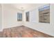 Bright bedroom with wood-look floors and three windows at 5713 W Rowel Rd, Phoenix, AZ 85083