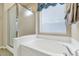 Bathroom with soaking tub, shower, and window with blinds at 3437 W Thoreau Ln, Anthem, AZ 85086