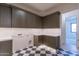 Bright laundry room with dark cabinetry, checkerboard floor, and access to a bedroom at 9633 E Quarter Circle Loop, Gold Canyon, AZ 85118