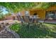 Landscaped backyard with patio furniture under a tree at 556 W Mirage Loop, Casa Grande, AZ 85122