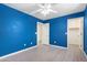 Blue bedroom with wood-look floors, ceiling fan, and closet at 4506 W Maggie Dr, San Tan Valley, AZ 85144