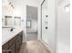 Modern bathroom with a walk-in shower, dark wood cabinetry, and white countertops at 21864 E Saddle E Ct, Queen Creek, AZ 85142