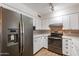 Updated kitchen with white cabinets, quartz countertops, and stainless steel appliances at 4943 E Indian School Rd # 4, Phoenix, AZ 85018