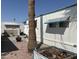 Backyard of mobile home with gravel, a fire pit, and a palm tree at 2460 E Main St # G3, Mesa, AZ 85213