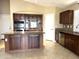 Spacious kitchen with island, dark wood cabinets and granite countertops at 21978 N Dietz Dr, Maricopa, AZ 85138