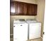 Laundry room with washer and dryer and wood cabinets at 21978 N Dietz Dr, Maricopa, AZ 85138