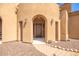 Elegant entryway with arched doorway and a brick pathway at 16738 E Lone Mountain Rd, Scottsdale, AZ 85262