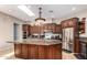 Spacious kitchen with dark wood cabinets, granite countertops, and stainless steel appliances at 16738 E Lone Mountain Rd, Scottsdale, AZ 85262