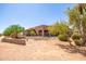 Backyard view of the house, showing a rock wall and desert landscaping at 16738 E Lone Mountain Rd, Scottsdale, AZ 85262