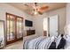 Bedroom with double doors leading to patio, TV and dresser at 16738 E Lone Mountain Rd, Scottsdale, AZ 85262