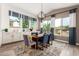 Spacious dining area with a wooden table and chairs, and large windows with curtains at 9649 E Solina Ave, Mesa, AZ 85212