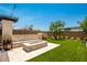 Fire pit area with stone seating wall in the backyard at 9649 E Solina Ave, Mesa, AZ 85212