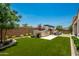 Landscaped backyard with artificial turf and outdoor kitchen at 9649 E Solina Ave, Mesa, AZ 85212