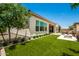 Landscaped backyard with grassy area, fire pit, and patio at 9649 E Solina Ave, Mesa, AZ 85212