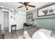 Well-lit bedroom with a gray bed frame, built-in shelving, and ceiling fan at 22831 N 103Rd Ln, Peoria, AZ 85383