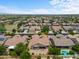 Aerial view of a residential neighborhood with a focus on a single-Gathering home with a pool at 16205 W Berkeley Rd, Goodyear, AZ 85395
