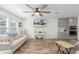 Bright living room with a large TV, comfy sofas, and ceiling fan at 16245 W Culver St, Goodyear, AZ 85338