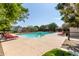 Large community pool surrounded by red lounge chairs at 16245 W Culver St, Goodyear, AZ 85338