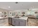 Open kitchen with island, stainless steel dishwasher, and access to backyard at 16245 W Culver St, Goodyear, AZ 85338