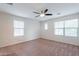 Main bedroom with carpeted floor, ceiling fan and large windows at 26964 N 104Th Ln, Peoria, AZ 85383