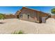 Rear view of house showcasing desert landscaping and AC unit at 45737 W Ranch Rd, Maricopa, AZ 85139