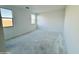 Spacious, empty bedroom with white walls and two windows at 47282 W Cansados Rd, Maricopa, AZ 85139