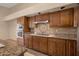 Well-equipped kitchen featuring granite counters and wood cabinets at 10923 W Escuda Dr, Sun City, AZ 85373