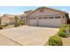 Tan house with a two-car garage and desert landscaping at 10923 W Escuda Dr, Sun City, AZ 85373