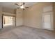 Large bedroom with ceiling fan and neutral carpeting at 10923 W Escuda Dr, Sun City, AZ 85373