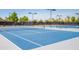 Two well-maintained tennis courts with surrounding fencing and lighting at 10923 W Escuda Dr, Sun City, AZ 85373