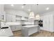 Modern kitchen with white cabinets, large island, and wood floors at 42158 N Golden Trl, San Tan Valley, AZ 85140