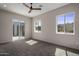 Bright bedroom with carpet flooring, ceiling fan, and sliding glass door to patio at 19617 N 39Th Dr, Glendale, AZ 85308