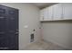 Laundry room with upper cabinets and built-in pet door at 19617 N 39Th Dr, Glendale, AZ 85308