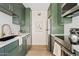 Modern galley kitchen with green cabinets, stainless steel appliances, and quartz countertops at 7350 N Via Paseo Del Sur -- # P202, Scottsdale, AZ 85258