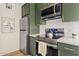 Stainless steel appliances and green shaker cabinets highlight this updated kitchen at 7350 N Via Paseo Del Sur -- # P202, Scottsdale, AZ 85258