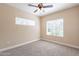 Well-lit bedroom with two windows, ceiling fan, and carpet floor at 5335 E Shea Blvd # 1042, Scottsdale, AZ 85254