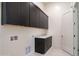 Modern laundry room with dark cabinetry and a utility sink at 8332 E Sand Flower Dr # 20, Scottsdale, AZ 85266