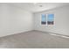 Bright bedroom with grey carpet and large window at 37287 W Patterson St, Maricopa, AZ 85138