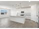 Modern kitchen with white cabinets and island at 37287 W Patterson St, Maricopa, AZ 85138