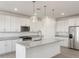 Modern kitchen with white cabinets, granite countertops, and stainless steel appliances at 37287 W Patterson St, Maricopa, AZ 85138