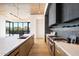 Modern kitchen with long island, stainless steel appliances, and dark cabinetry at 10249 E Joy Ranch Rd, Scottsdale, AZ 85262