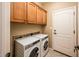 Laundry room with wood cabinets and stacked washer/dryer at 13747 W Nogales Dr, Sun City West, AZ 85375