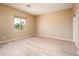 Empty bedroom with light wood flooring and large window at 13747 W Nogales Dr, Sun City West, AZ 85375
