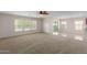 Spacious living room with large windows and ceiling fan at 17214 W Gibson Ln, Goodyear, AZ 85338