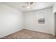 Well-lit bedroom with ceiling fan, neutral wall colors, and carpeted flooring at 2084 N 214Th Dr, Buckeye, AZ 85396