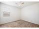 Bright bedroom featuring neutral walls, carpeted floors, and a ceiling fan at 2084 N 214Th Dr, Buckeye, AZ 85396