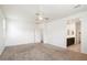Main bedroom with carpet flooring, ceiling fan, and en-suite bathroom access at 2084 N 214Th Dr, Buckeye, AZ 85396