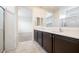 Modern bathroom with double vanity, large mirror, and walk-in shower at 2084 N 214Th Dr, Buckeye, AZ 85396