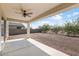 Covered patio with ceiling fan, overlooking a gravel backyard at 2084 N 214Th Dr, Buckeye, AZ 85396